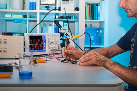 An engeneer tests electronic components with oscilloscope in the service centreの写真素材