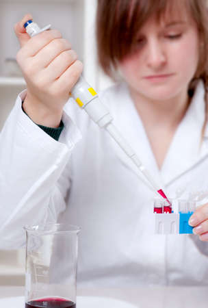 Young tech pipetting sample into eppindorf tubes, shallow DOW, focus on the handの写真素材