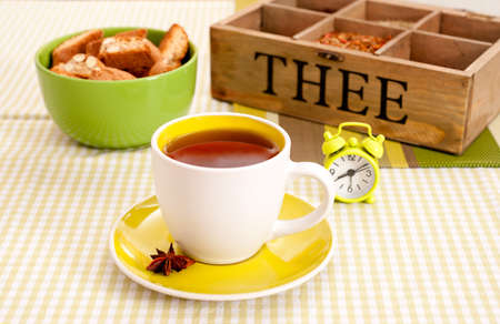 Cup of black tea, bisquits and a box with assorted tea mixturesの写真素材