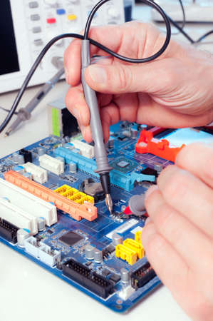 Tech tests electronic equipment in service centreの写真素材