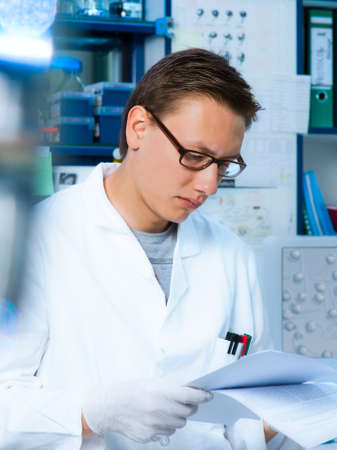 Young scientist reads a paperの写真素材