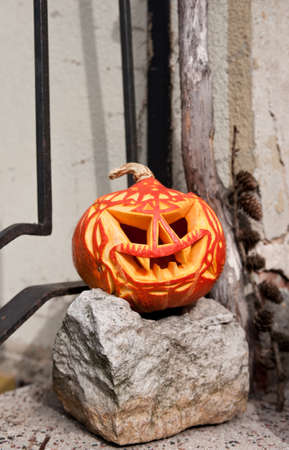 Carved halloween pumpkin on top of grey stoneの写真素材