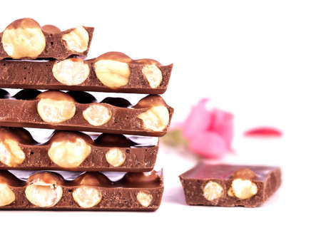Chocolate with nuts and a rose isolated on whiteの写真素材