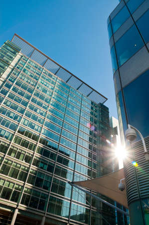Sun shining between office blocks in London Canary Wharfの写真素材
