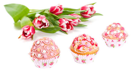 Decorated cupcakes and bunch of tulips on white backgroundの写真素材