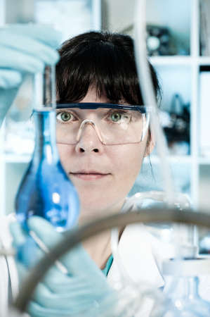 Female tech in protective wear works in chemical labの写真素材