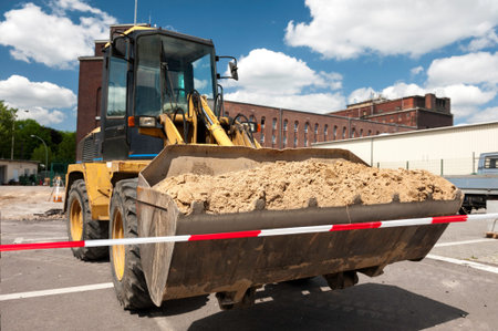 Bulldozer with sand in a scoop on industrial site