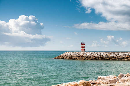 Lighthouse on a pier in Quarteira, Southern Portugalの写真素材