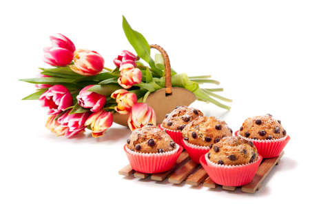 Chocolate chip muffins and a bunch of tulips on white backgroundの写真素材