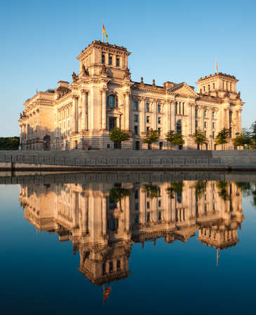 The Reichstag building (Bundestag) with reflection in river Spree early in the morningの写真素材