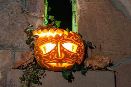 Jack o'Lantern on Halloween night by a narrow castle windowの写真素材