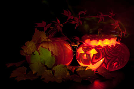 Jack o'Lantern and a large pumpkin on black backgroundの写真素材