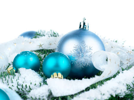 Christmas decorations on top of Xmas tree twigs covered with snowの写真素材