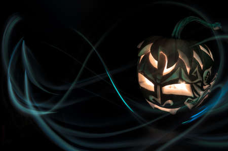 Halloween pumpkin with candle inside on black background, light brush techniqueの写真素材
