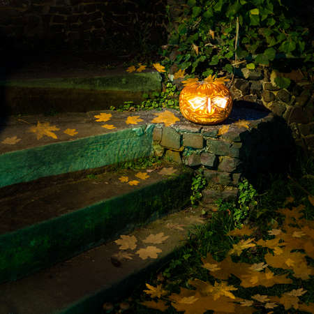 Jack o'Lantern by old staircase at nightの写真素材