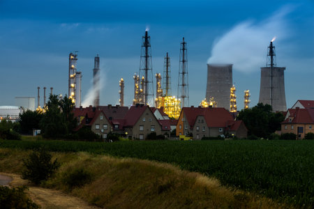 chemical factory in dawn with rural houses in front of it