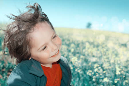 Happy little boy on a flower field, tinted imageの写真素材