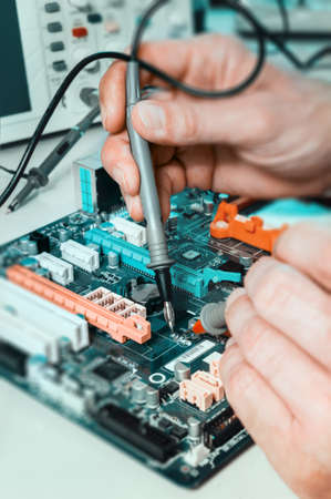 Male tech tests electronic equipment in service centreの写真素材