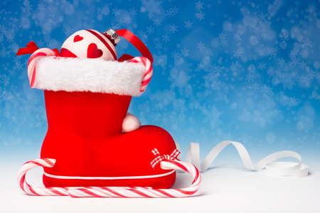 Santa's boot and Xmas canes on blue winter backgroundの写真素材
