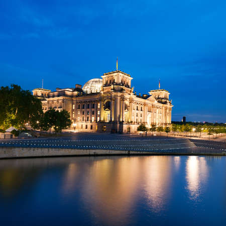 The Reichstag building  Bundestag  with reflection in river Spree at nightの写真素材