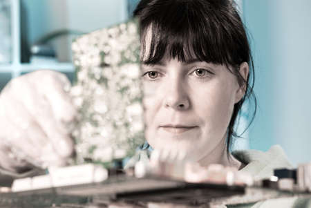 Electronics repair tech fixes surcuit boardの写真素材