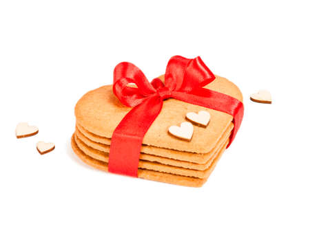 Geart-shaped gingerbread cookies tied up with red ribbon on white backgroundの写真素材