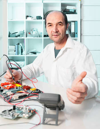 Senior repair tech assures you he fixes your electronic deviceの写真素材