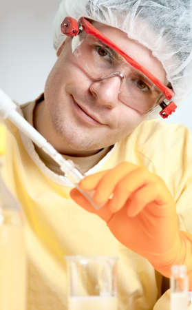 Young microbiologist in protective workwear smiles into cameraの写真素材