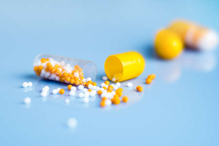Yellow capsules on blue , one split openの写真素材