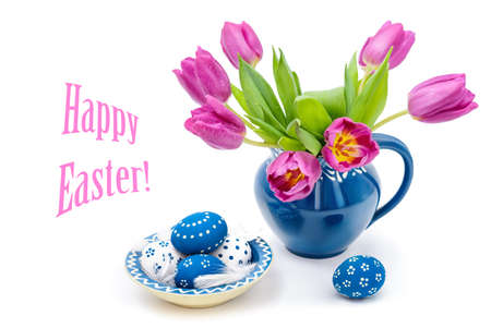 Blie ceramic vase with tulips and matching plate with painted Easter Eggs on white backgroundの写真素材