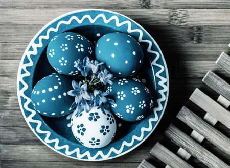 Turquoise Easter Eggs in matching ceramics bown on wooden backgroundの写真素材