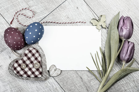 Empty card surrounded by Easter decorations on wooden surface, text spaceの写真素材