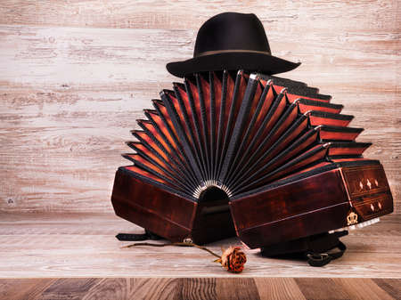 Bandoneon on wooden with a male black hat on top, text spaceの写真素材