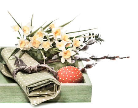 Box with Easter decorations on white 