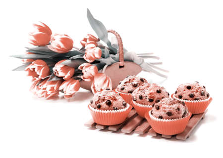 Chocolate chip muffins and a bunch of tulips on white background, tinted imageの写真素材