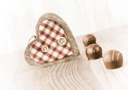 Row of chocolates and decorative heart on wooden background, text spaceの写真素材