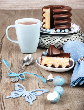 German baumkuchen on a wooden table with blue spring decorations