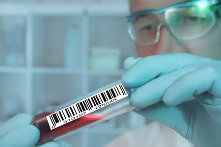 Tech with a medical sample labeled with a barcodeの写真素材
