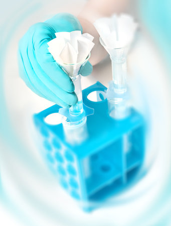 Scientific background, gloved hand holds a funnel with paper filter, text space