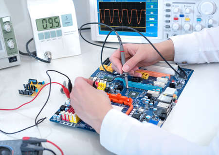Tech tests electronic equipment in service centreの写真素材