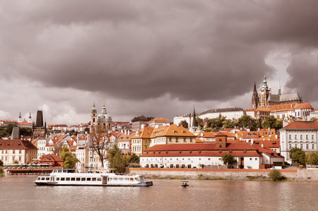 View on Prague Castle across Vltava river; early autumn; sunlit old roofs under dramatic skyのeditorial素材