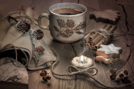 Hot tea, burning candle and Christmas cookies on decorated table, toned imageの写真素材