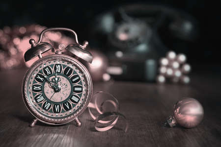Composition with vintage alarm clock showing five to midnight and an old phone. Happy New Year 2015!の写真素材