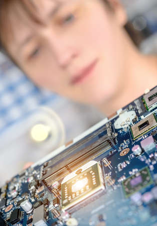 Closeup on motherboard observed by a tech for possible defectsの写真素材