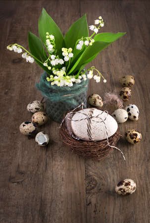 Lily of the valley and Easter decorations on old wood, text space. Happy Easter!の写真素材