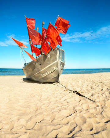 Traditional fisherman boat on a sandy shore of the Baltic Sea. Baabe willage, island Rugen, Germanyの写真素材