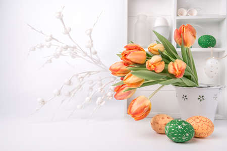 Easter greeting card design with bunch of tulips and painted eggs on abstract white backgroundの写真素材