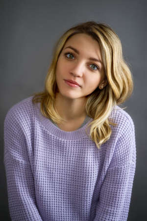 Portrait of a young attractive girl with long straight hair with highlights on gray background, looking at the cameraの写真素材