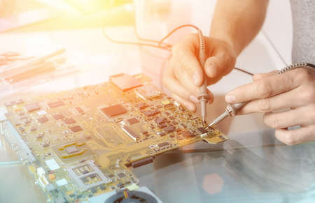 Computer repair service; hands of male tech testing motherboardの写真素材