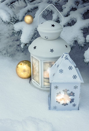 Little winter lanterns outdoors on a Christmas tree under snow. Merry Christmas!の写真素材
